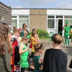 Pupils at Powers Hall Academy show off their Get Witham Reading costumes to Priti Patel, while Peter Pan looks on.