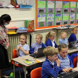 A pupil at Rivenhall C of E Primary School discusses her reading project with Witham MP, Priti Patel