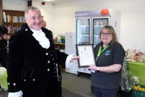 Inside the new Witham Hub, The High Sheriff of Essex, Simon Brice DL, presents Tina Townsend, with a special community award for her hard work during the pandemic.