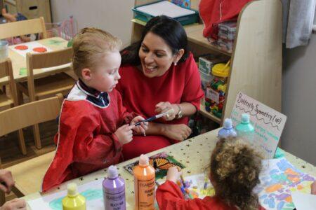 Priti Patel enjoys sharing a painting project with one of the children at Busy Bee’s Nursery.
