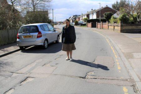 Priti Patel on the very badly damaged road surface in Rectory Road.