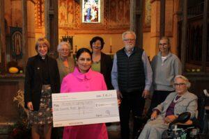 Priti Patel MP presents her donation to the Rev Anne-Marie Renshaw and volunteers from the Friends of Copford Church.