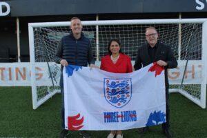 Priti with Gary White (right), Chairman of Heybridge Swifts and Tim Bruce – Club Committee Member, proudly supporting England’s world cup team, during her tour of the Heybridge Swifts’ Stadium.