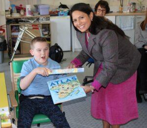Priti Patel presents Kyle with his prizes for winning the MP’s Christmas card competition, a world atlas and a jigsaw puzzle.
