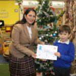 Alex Harkins, aged 6, receives his runner-up certificate from Priti Patel MP at Howdens Infant School.