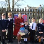 Priti Patel MP presenting a basket of seeds and gardening tools to pupils at Tiptree Heath Primary School.