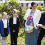 Priti Patel MP visiting Powers Hall Academy and presenting the students with a basket full of goods.